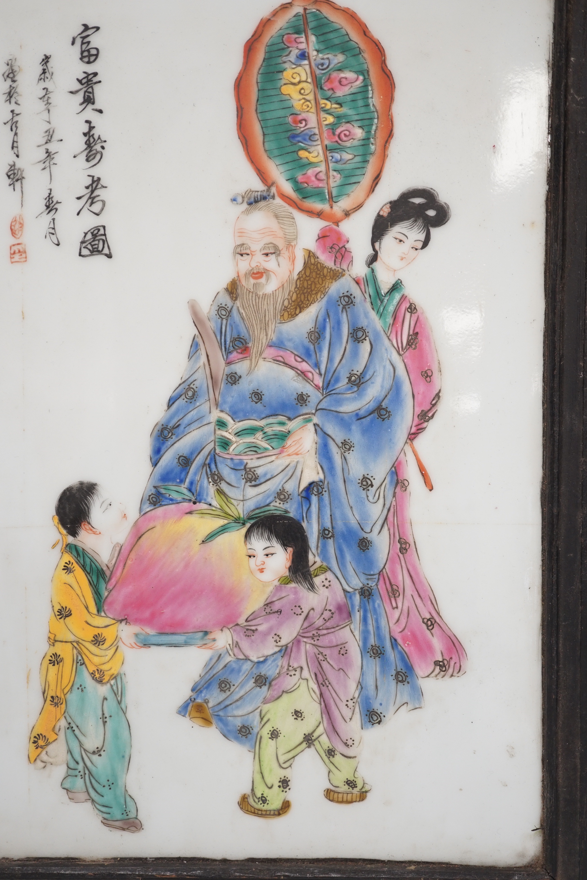 A framed Chinese porcelain plaque decorated with figures and calligraphy, overall 40cm x 29cm